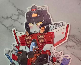 May include: A die-cut vinyl sticker featuring a central red and white robot character with yellow eyes, holding two smaller robot figures. The central figure has a black helmet with a small grey robot on top, and small red hearts are visible on its wings.