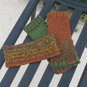 May include: Three crocheted headbands in shades of brown, orange, green, and purple. Each headband has a brown leather tag with the text "Shady Shelter" on it.