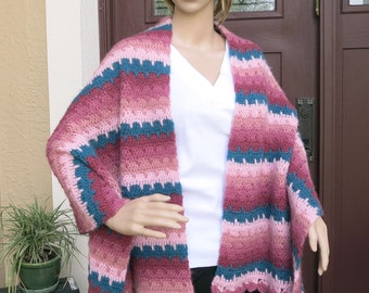 Könnte beinhalten: Ein gestrickter Schal in Rosa und Türkis mit einem gewellten Rand.