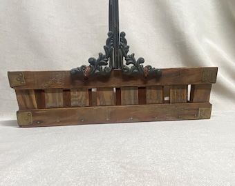 Cesta rústica de madera con listones, esquinas de latón y asa de hierro forjado.