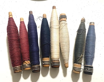 Antique wooden weaving loom shuttle bobbins or spools.