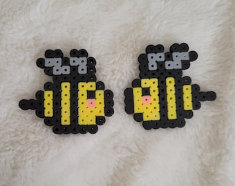 May include: Two yellow and black bee-shaped bead sprites with gray antennas and pink cheeks.