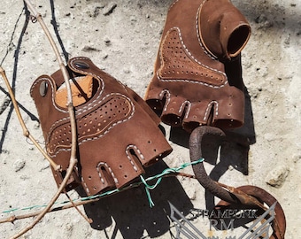 Puede incluir: Dos guantes sin dedos de cuero marrón con costuras blancas y agujeros. Los guantes están sobre una superficie de hormigón con un candado de metal y un cartel que dice "STEAMPUNK RM Leather patterns Digital goods".