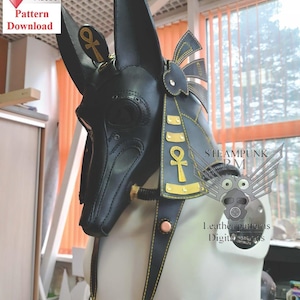 May include: Black leather Anubis mask with gold accents and an Ankh symbol. The mask features long, pointed ears and is designed with intricate details. The image includes a "Pattern Download" graphic.