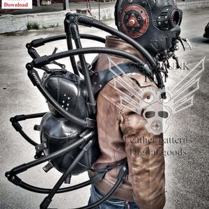 May include: A black leather steampunk backpack with a spider-like design. The backpack has multiple black tubes and metal accents. The backpack is being worn by a person wearing a brown leather jacket and blue jeans.