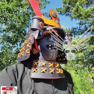 May include: A black and red leather samurai helmet with orange and gold accents. The helmet features a distinctive red crest and is adorned with yellow stitching. The image also includes a PDF download icon.