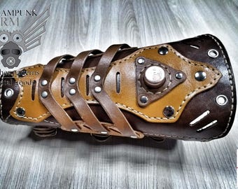 May include: Brown leather steampunk arm cuff with a tan leather panel and metal accents. The cuff has a decorative design with straps and rivets. The cuff is a digital download pattern.