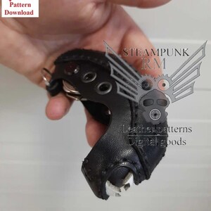 Könnte beinhalten: Ein schwarzer Leder-Schlüsselanhänger im Steampunk-Stil mit einem Metallzahnrad-Design und dem Text "STEAMPUNK RM Leather patterns Digital goods".