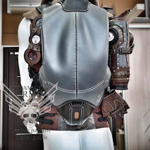 May include: A gray leather steampunk-style backpack with brown leather straps and buckles. The backpack has a variety of metal gears and other steampunk-style embellishments. The backpack is being worn by a mannequin.