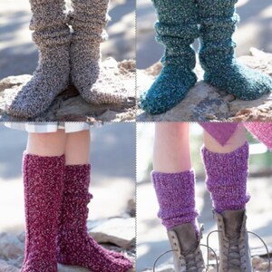 May include: Four pairs of knitted socks in various colours. The socks are shown on legs, with colours including grey, teal, burgundy, and purple. The socks are slouchy and have a textured appearance, with some pairs worn with boots.