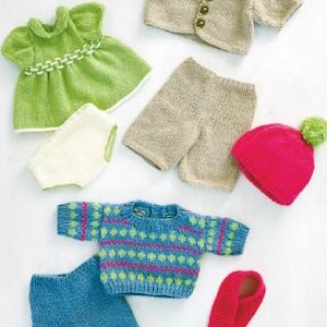 May include: A selection of knitted teddy bear clothes in different colours. Includes a green dress, beige shorts, a blue patterned sweater, a red hat with a green pom-pom, and a red scarf. The text "Everything teddy needs for playtime" is visible.