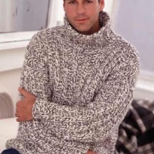 Puede incluir: Un suéter de cuello alto de punto de cable gris y blanco. El suéter tiene un patrón grueso y texturizado y un cuello alto. El modelo lleva vaqueros azules. El suéter parece estar hecho de un hilo cálido y grueso, adecuado para el clima frío.