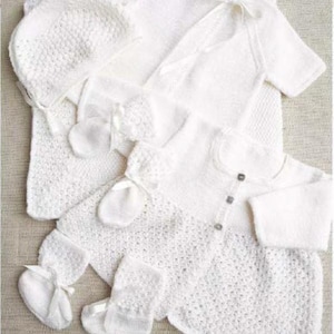 Op de afbeelding: Een set witte gebreide babykleding, inclusief een muts, deken, trui, babyslofjes en wanten. De set heeft delicate strikjes en knoopdetails, ideaal voor een pasgeborene. De items zijn op een neutrale ondergrond geplaatst.