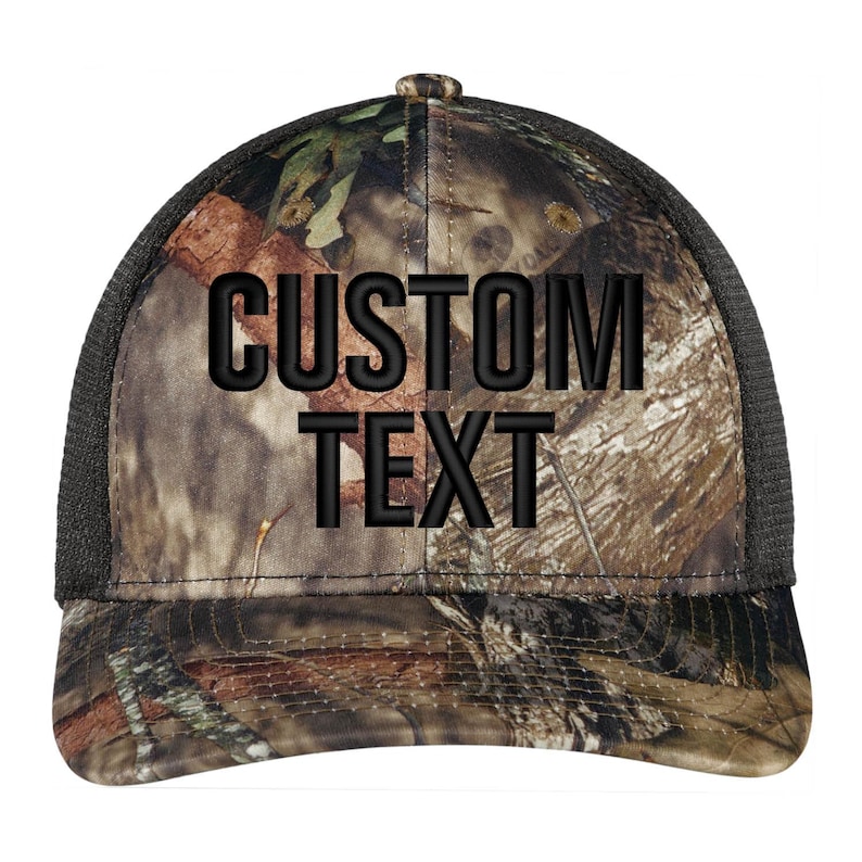 May include: A black and brown camouflage trucker hat with a black mesh back. The hat has the text "CUSTOM TEXT" embroidered in black on the front.