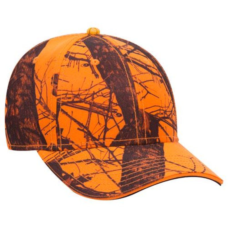 May include: An orange and brown camouflage baseball cap. The cap features a curved brim and a button on top. The pattern resembles tree branches and foliage, creating a hunting or outdoor theme. The cap is made of a durable fabric.