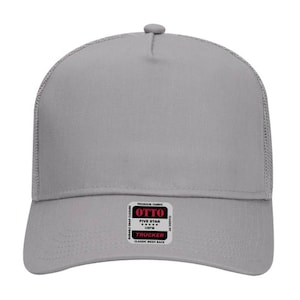 May include: A gray trucker hat with a mesh back and a curved brim. The hat features a snap closure and a patch with the text "OTTO FIVE STAR OSFM TRUCKER CLASSIC MESH BACK". The hat is made of premium fabric.