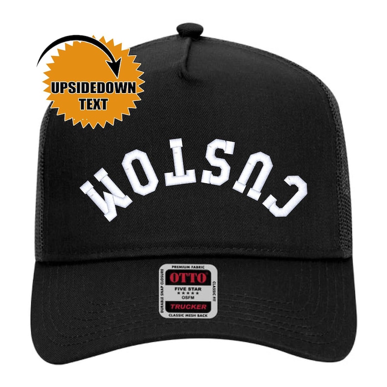 May include: Black trucker hat with the white word "CUSTOM" arched across the front. The hat has a mesh back and a snap closure. The hat also has a small patch that says "OTTO" and "TRUCKER". An orange burst with the words "UPSIDEDOWN TEXT" is in the upper left corner.