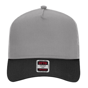 May include: A gray and black trucker hat with a mesh back. The hat features a gray front panel and a black brim. A rectangular patch on the front reads "OTTO TRUCKER CLASSIC MESH BACK".