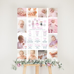 May include: A pink and white baby milestone poster with photos of a baby girl. The poster includes information about the baby's age, weight, and milestones. The poster is decorated with snowflakes and a ballerina illustration.