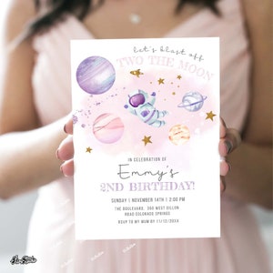 May include: A pink and purple space-themed birthday invitation with a cartoon astronaut and planets. The text reads "Let's blast off Two the Moon" and "Emmy's 2nd Birthday!"  Sunday, November 14th, 2:00 PM. The Boulevard, 350 West Dillon Road, Colorado Springs. RSVP to my Mum by 11/12/20XX.