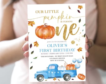 May include: A white invitation card with a blue truck carrying pumpkins and balloons. The text on the card reads "Our little pumpkin is turning one. Join us to celebrate Oliver's First Birthday. Sunday, February 12th | 2:00 PM. The Boulevard, 350 West Dillon Road, Colorado Springs. RSVP by 11/12/20XX."