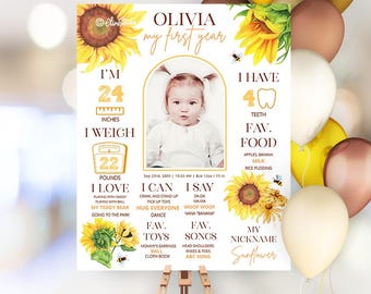 Może przedstawiać: Spersonalizowany znak na pierwsze urodziny ze zdjęciem dziecka, słonecznikami i tekstem. Znak zawiera wymiary dziecka: 61 cm wzrostu i 10 kg wagi. Wymienia ulubione jedzenie, zabawki i piosenki.