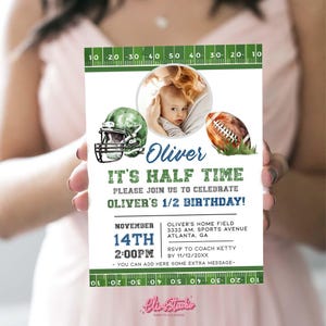 May include: A green and white football-themed invitation for a half birthday party. The invitation features a photo of a baby boy, a football helmet, and a football. The text on the invitation reads "Oliver's Half Time" and "Please join us to celebrate Oliver's 1/2 Birthday!" The invitation also includes the date and time of the party, as well as the location.
