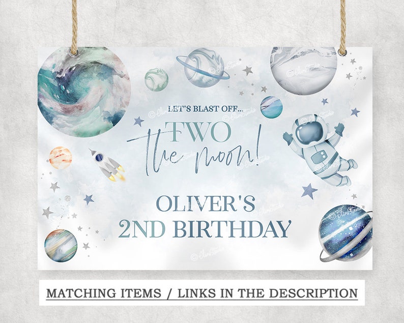 May include: A blue and white space-themed birthday sign with the text "Let's Blast Off... Two the Moon! Oliver's 2nd Birthday" and illustrations of planets, stars, a rocket, and an astronaut.