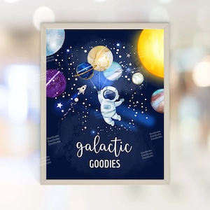 May include: A blue and white astronaut holding colorful planets as balloons against a dark blue starry sky. The text "galactic goodies" is written below the astronaut.