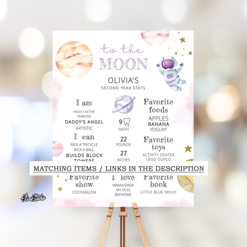 May include: A pink and purple illustrated poster with a space theme. The poster features a cartoon astronaut, planets, and stars. The text on the poster reads "To the Moon, Olivia's Second Year Stats". The poster also includes information about Olivia's age, height, weight, and favorite foods and toys.
