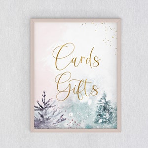 May include: A white sign with a gold frame and a watercolor background. The sign says "Cards Gifts" in gold script.