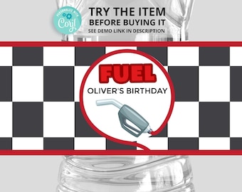 May include: A black and white checkered background with a red circle containing the word "FUEL" in red letters and the text "Oliver's Birthday" in black letters. A gray gas pump nozzle is inside the circle.