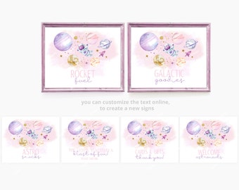 May include: Watercolor space-themed signs in pink and purple. Each framed print features planets, an astronaut, and a rocket. Text includes "Rocket Fuel" and "Galactic Goodies". Additional signs say "Astro Snacks", "Cards & Gifts", and "Welcome Astronauts".