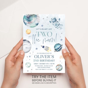 May include: A blue and white invitation card with a watercolor illustration of planets, stars, and an astronaut. The text on the card reads "Let's Blast Off Two The Moon!" and "Oliver's 2nd Birthday!"
