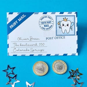 May include: A white envelope with "FAIRY MAIL" printed on a blue diagonal stripe. The envelope has a stamp with a cartoon tooth fairy and the text "TOOTH FAIRY MAIL". Two coins and star-shaped confetti are on a blue background.