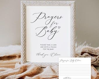 May include: A white framed sign with the text "Prayers for Baby" in cursive script. The sign also includes the text "Please take a card and write a prayer for the baby." A small card is also present.