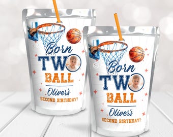 May include: Two juice pouches with a basketball theme. The pouches are silver with a blue and orange basketball hoop and ball design. The text on the pouches reads "Born Two Ball Oliver's Second Birthday!"