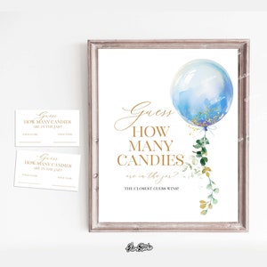 Puede incluir: Un globo azul y dorado con vegetación cuelga sobre un cartel que dice "Adivina cuántos caramelos hay en el frasco? ¡La adivinanza más cercana gana!"  Este es un cartel imprimible para un juego de baby shower.