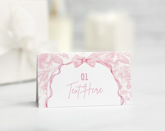 May include: Pink floral place card with a pink ribbon and bow. The card has the number "01" and the text "Text Here".