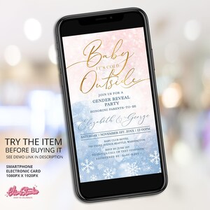May include: A smartphone screen displaying a baby shower invitation with a blue and pink watercolor background. The invitation reads "Baby It's Cold Outside" with snowflakes and gold lettering. The text includes the date, time, location, and RSVP information.