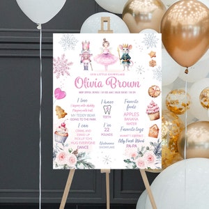 May include: A pink and white printable baby milestone sign with a watercolor design featuring a nutcracker, a ballerina, and a mouse. The sign includes the baby's name, Olivia Brown, birth date, time, weight, and length. It also includes a list of the baby's favorite foods, toys, and activities.