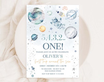 May include: A blue and white invitation with a watercolor space theme. It says "5,4,3,2.. ONE!" and "Please join us as we celebrate Oliver's first trip around the sun". The invitation includes a rocket, astronaut, planets, and stars.