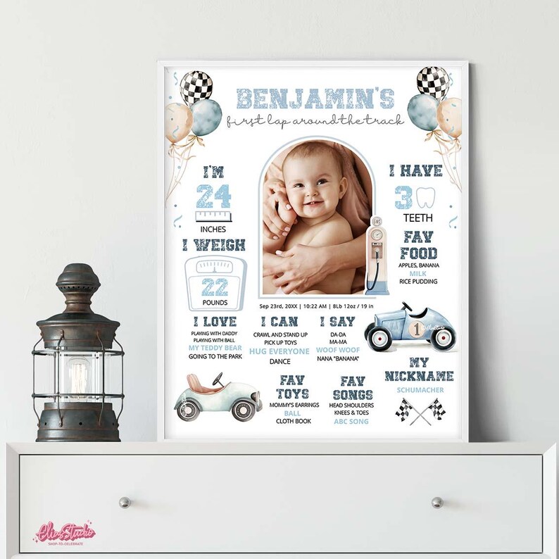 Op de afbeelding: Een ingelijste baby-mijlpaalposter met een foto van een baby. De poster bevat de naam van de baby, de afmetingen, favoriete dingen en mijlpalen. De poster heeft een racewagenthema met blauwe en witte accenten.