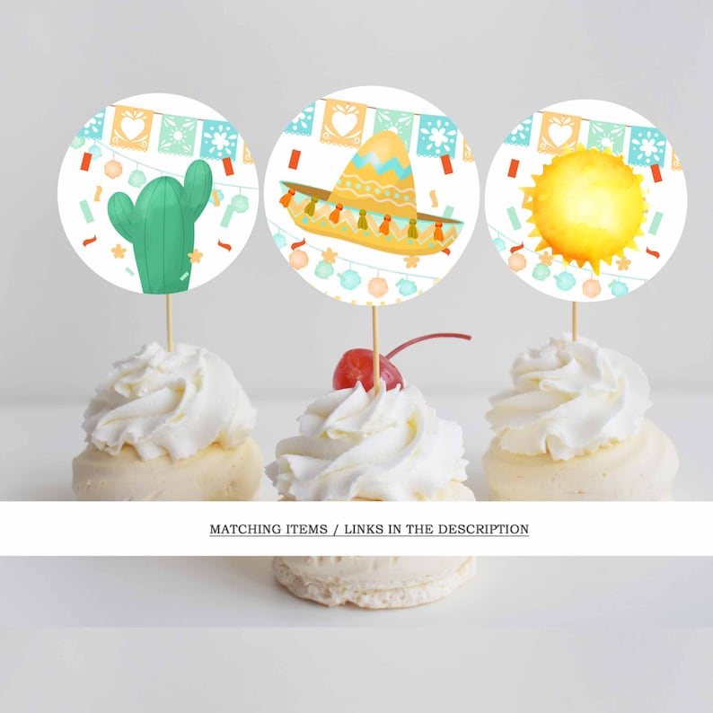 May include: Three cupcakes topped with decorative toppers. The toppers feature a green cactus, a sombrero, and a sun. The toppers are round with a festive design. The cupcakes are decorated with white frosting and a cherry.