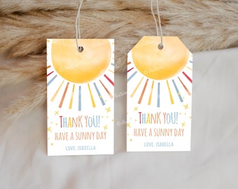 Könnte beinhalten: Zwei weiße Geschenkanhänger mit einem Aquarell-Sonnendesign. Die Sonne ist gelb mit bunten Strahlen. Auf den Anhängern steht "THANK YOU! HAVE A SUNNY DAY" und "LOVE, ISABELLA". Jeder Anhänger hat eine Schnur zum Befestigen.