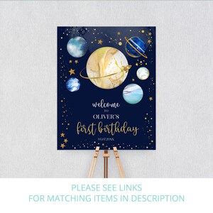 May include: A blue and gold welcome sign with planets and stars. The text reads "Welcome to Oliver's First Birthday 05.07.20XX".