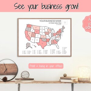 May include: A printable US state sales map with a pink and gray color scheme. The map is framed and hanging on a white wall. The text "See your business grow!" is at the top of the image. The text "YOUR BUSINESS NAME US State Sales Map" is at the top of the map. The text "Print + hang in your office!" is at the bottom of the image. The text "Add your LOGO!" is in a pink circle at the top right of the image.