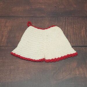 May include: White crocheted pot holder with a red crocheted trim.
