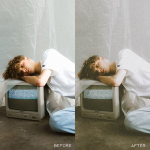 May include: A person laying on a vintage television with a white shirt and blue jeans. The television has static on the screen. The background is a white textured wall.
