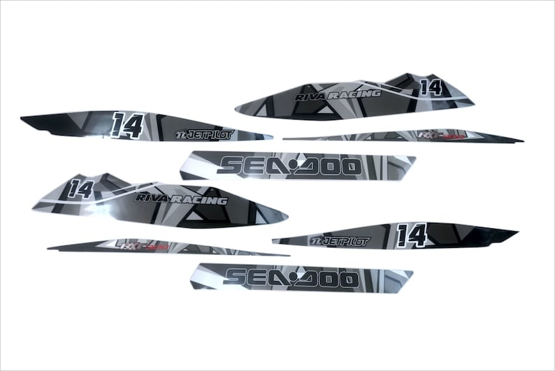 May include: A set of black and gray Sea-Doo watercraft decals with a geometric design. The decals feature the text "Sea-Doo", "Riva Racing", and "Jetpilot", along with the number "14".